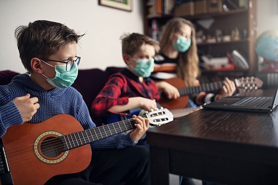 students playing guitar in masks