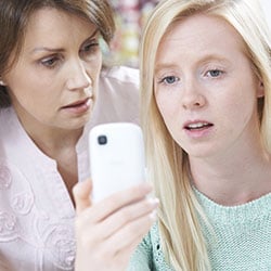 mother and daughter looking at a mobile phone