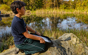 Boy in front of lake